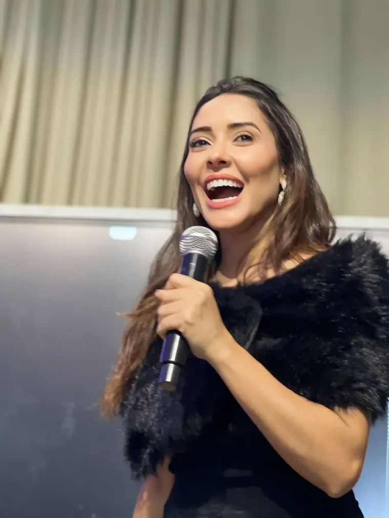 Deolane Paz ao microfone conduzindo um treinamento presencial